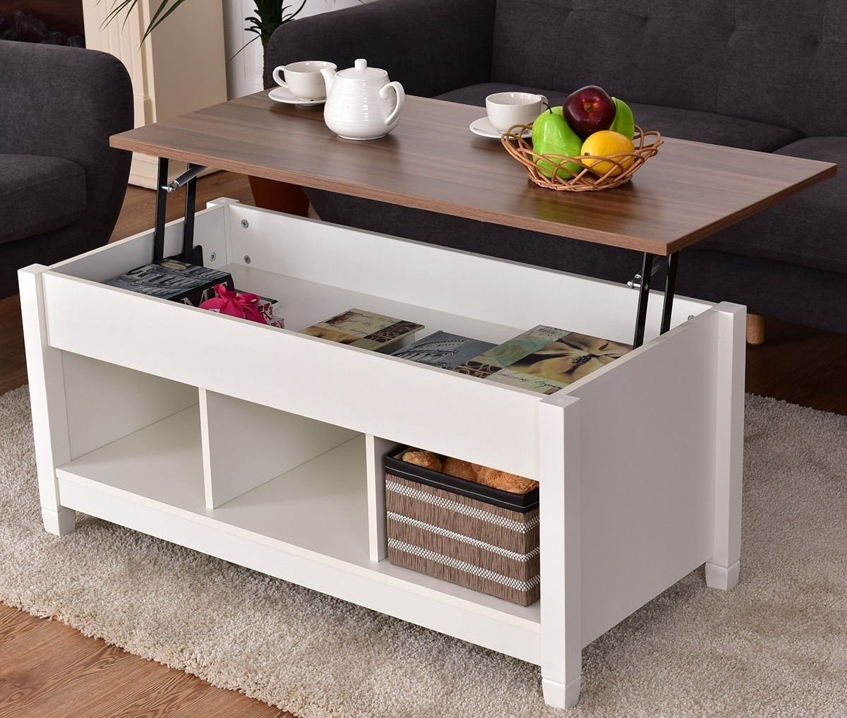 the lift top coffee table opened with books and snacks inside