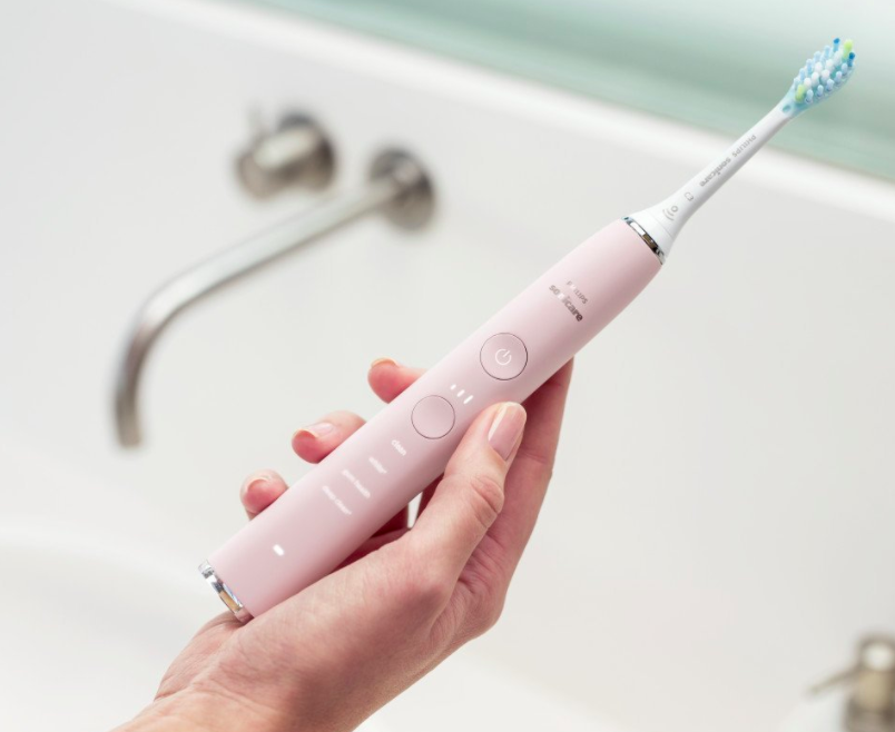 Hand holding pink toothbrush