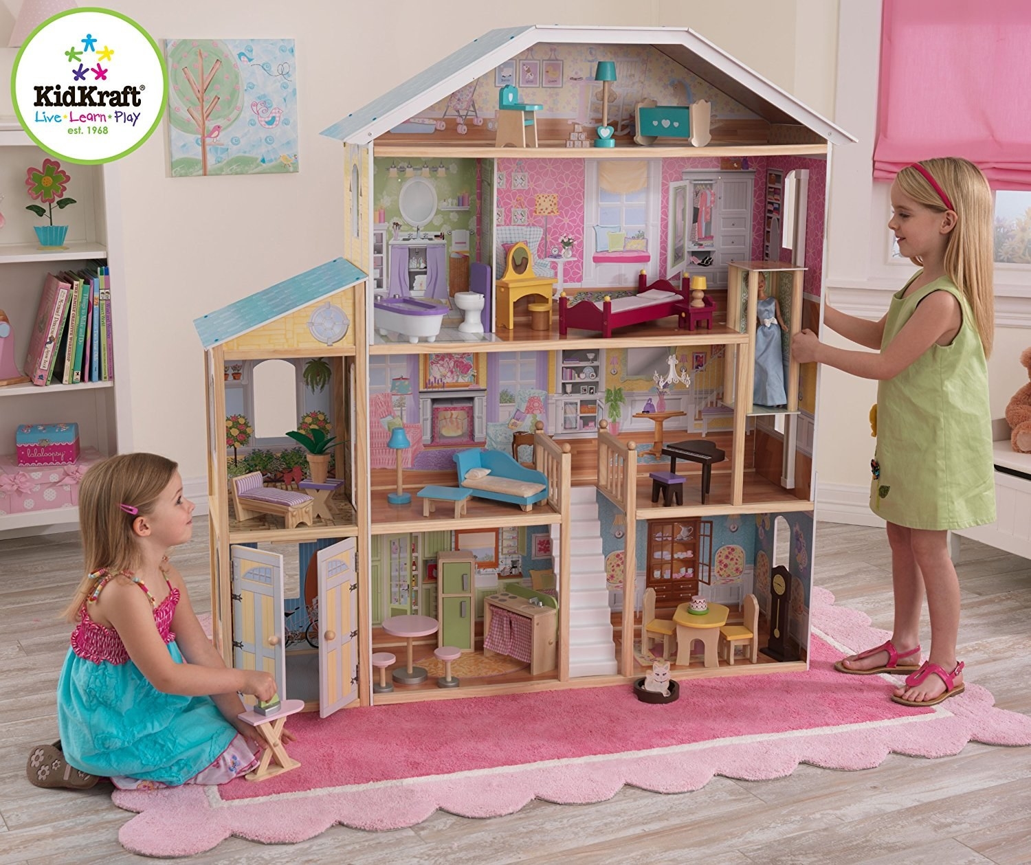 Two little girls playing with the giant dollhouse