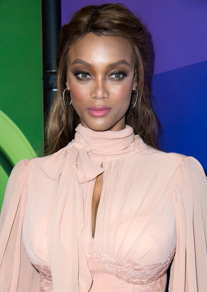 Tyra Banks shows a glimpse of her midriff in a tied up T-shirt and