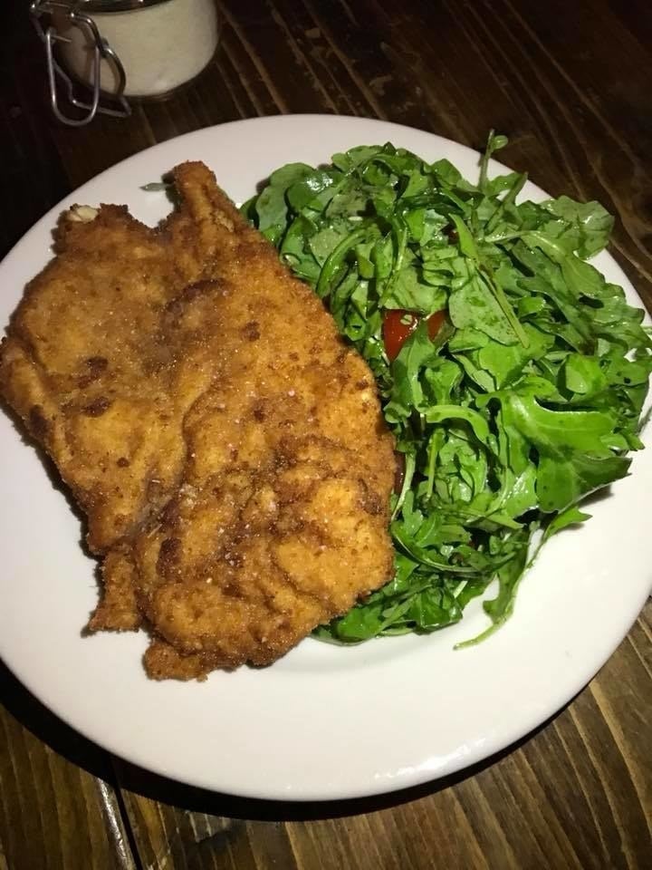 Organic chicken breast that had been pounded for tenderness is breaded and then pan-fried for the perfectly crispy exterior. The cutlet - seasoned with salt, pepper, and grated parmigiano - is served with arugula and cherry tomatoes tossed in olive oil.