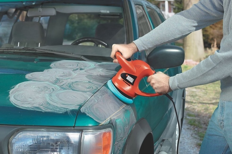 person buffing hood of car 