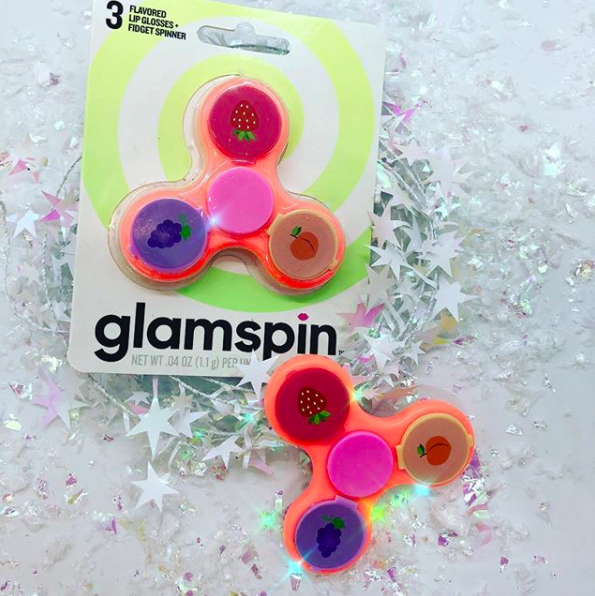 A glamspin, AKA a fidget spinner with three flavors of lipgloss, for the super cool kid or adult in your life. We're not judging.