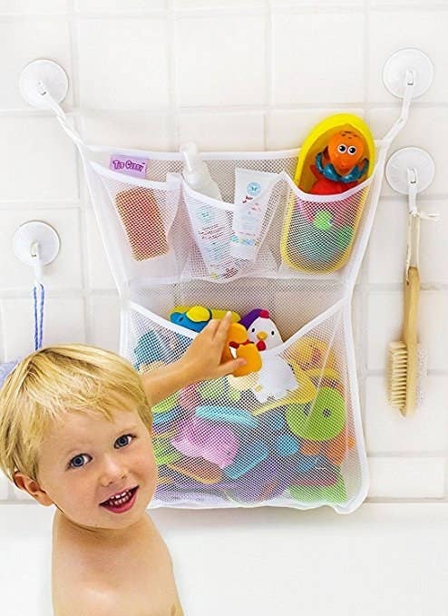 The mesh organizer containing bath toys and stuck to the wall