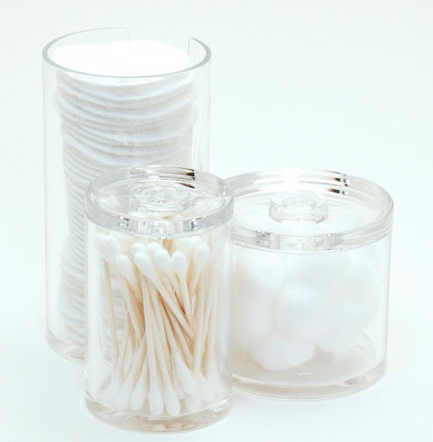 Put cotton swabs, pads, and puffs into an acrylic storage container. This way you can buy in bulk, store extras in the cabinet, and keep only what you need out on the counter.