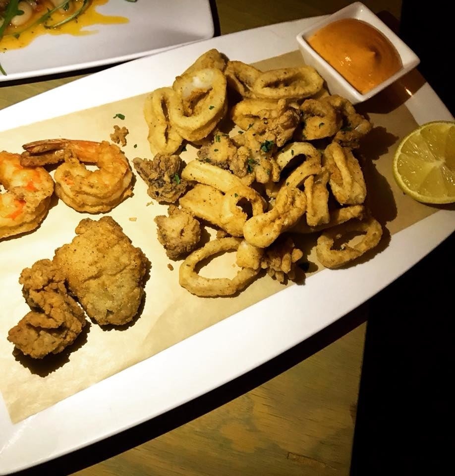 A medley of all your favorite seafood, Burnt Fingers features crispy fried calamari, shrimp, and oysters topped with parsley and with a side of creamy spicy aioli.