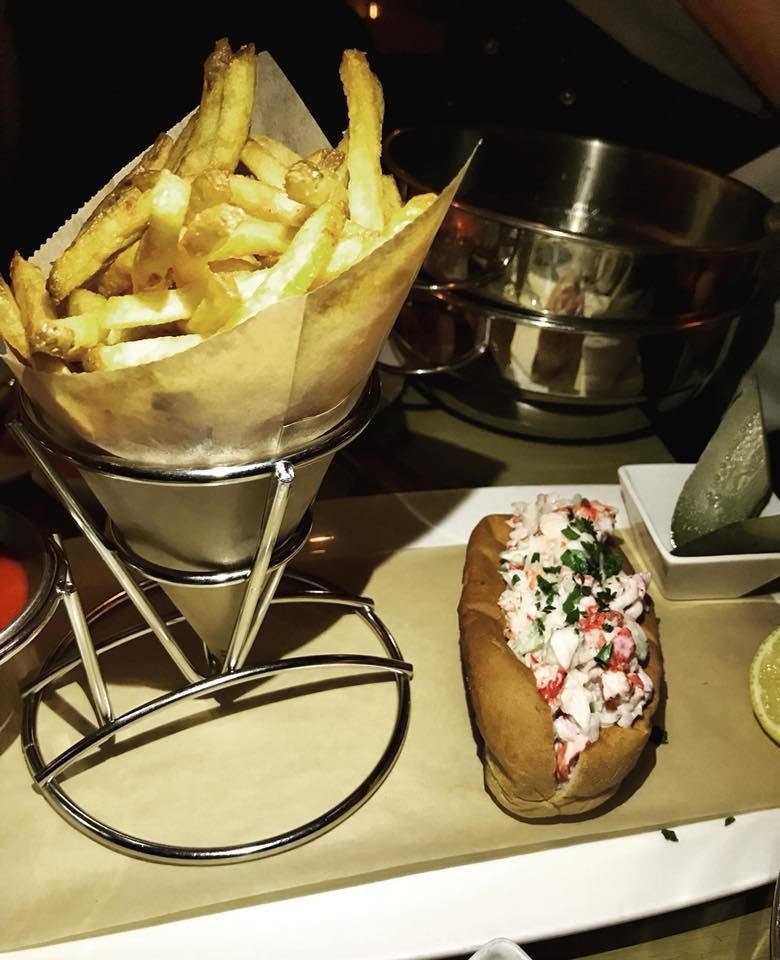 The lobster roll is packed with fresh chunks of lobster mean tossed in refreshing citrus aioli in buttery, toasted bun. The lobster roll is served with a side of crispy flex fries, pickles, and lemon.