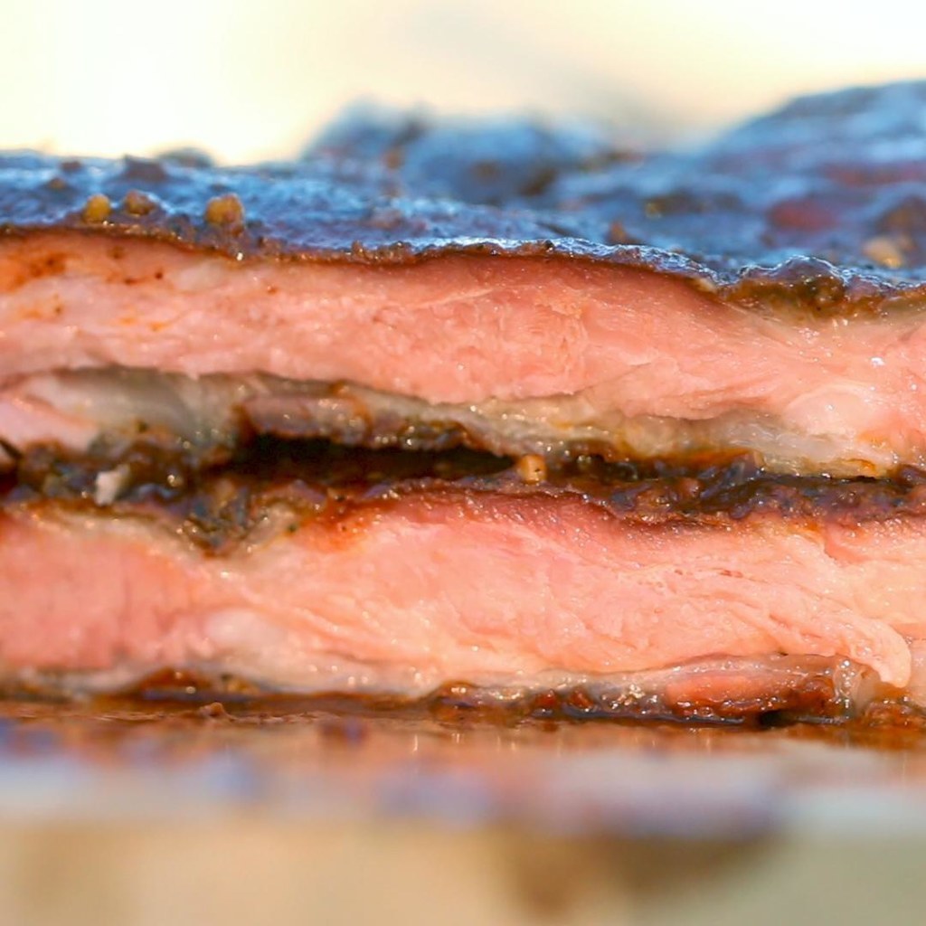 4 PortionenZUTATEN1 große Schweine-RippchenBBQ-Sauce, optionalGerebelte Gewürze1 Esslöffel gemahlener Ingwer1/2 Esslöffel Cayennepfeffer1 Esslöffel Knoblauchpulver2 Esslöffel Paprika1 Esslöffel gehackter Knoblauch2 Esslöffel Zwiebelpulver1 1/2 Esslöffel gemahlener schwarzer Pfeffer1 1/2 Esslöffel SenfpulverZUBEREITUNG1. Den Smoker anheizen, dazu 6-8 Kohlestücke anzünden und vollständig brennen lassen. Die Feuerbox aufsetzen und die Räucherkammer auf etwa 105°C anheizen, bei Bedarf noch Kohle nachfüllen. 2. In der Zwischenzeit Ingwer, Cayenne-Pfeffer, Knoblauchpulver, Paprika, Knoblauch, Zwiebelpulver, schwarzen Pfeffer und Senfpulver in einer Schüssel gründlich vermischen.3. Die Rippchen auf einen großen Bogen Alufolie legen und großzügig von allen Seiten mit Gewürzen einreiben.4. Einen mit Wasser gefüllten Metalltopf ans Ende des Garraumes nahe zum Feuerraum platzieren. Die Rippchen direkt auf den Rost der Garkammer legen und die Räucherkammer schließen. Die Klappen an beiden Enden der Räucherkammer öffnen.5. Ein oder zwei Stücke Räucherholz jede halbe Stunde in die Feuerkammer nachlegen, um einen Strom von dünnem, aber sichtbarem Rauch, der etwas bläulich aussieht, zu erzeugen. Zu viel Holz kann zu dickem, grauen Rauch führen. In diesem Fall muss man die Räucherkammer öffnen und den Rauch abziehen lassen, dann mit dem Schließen abwarten, bis man wieder überschaubaren Rauch erzeugen kann. 6. Die Wärme sollte durch das Hinzufügen von zusätzlicher Holzkohle, wenn erforderlich, konstant gehalten werden.7. Die Rippchen für ca. 3-5 Stunden smoken, einmal pro Stunde mit Wasser besprühen, um das Austrocknen des Fleisches zu vermeiden.8. Die Garzeit variiert je nach Größe und Art der Rippchen (Jungschweinrücken gart schneller als Schweinerippchen). Verwende ein Fleisch-Thermometer, um die Garstufe zu messen.9. Bei 75°C die Rippchen aus der Räucherkammer nehmen und auf einen großen Bogen Alufolie legen. Wenn Barbecue-Sauce verwendet wird, kann sie jetzt mit einem Bratenpinsel aufgetragen werden. Die Rippchen in der Aluminiumfolie einpacken und für weitere 30 Minuten in die Räucherkammer legen.10. Das Fleisch mindestens 15 Minuten vor dem Aufschneiden abkühlen und ruhen lassen. Mit der restlichen Barbecue-Sauce und bevorzugten Beilagen servieren.11. Guten Appetit!