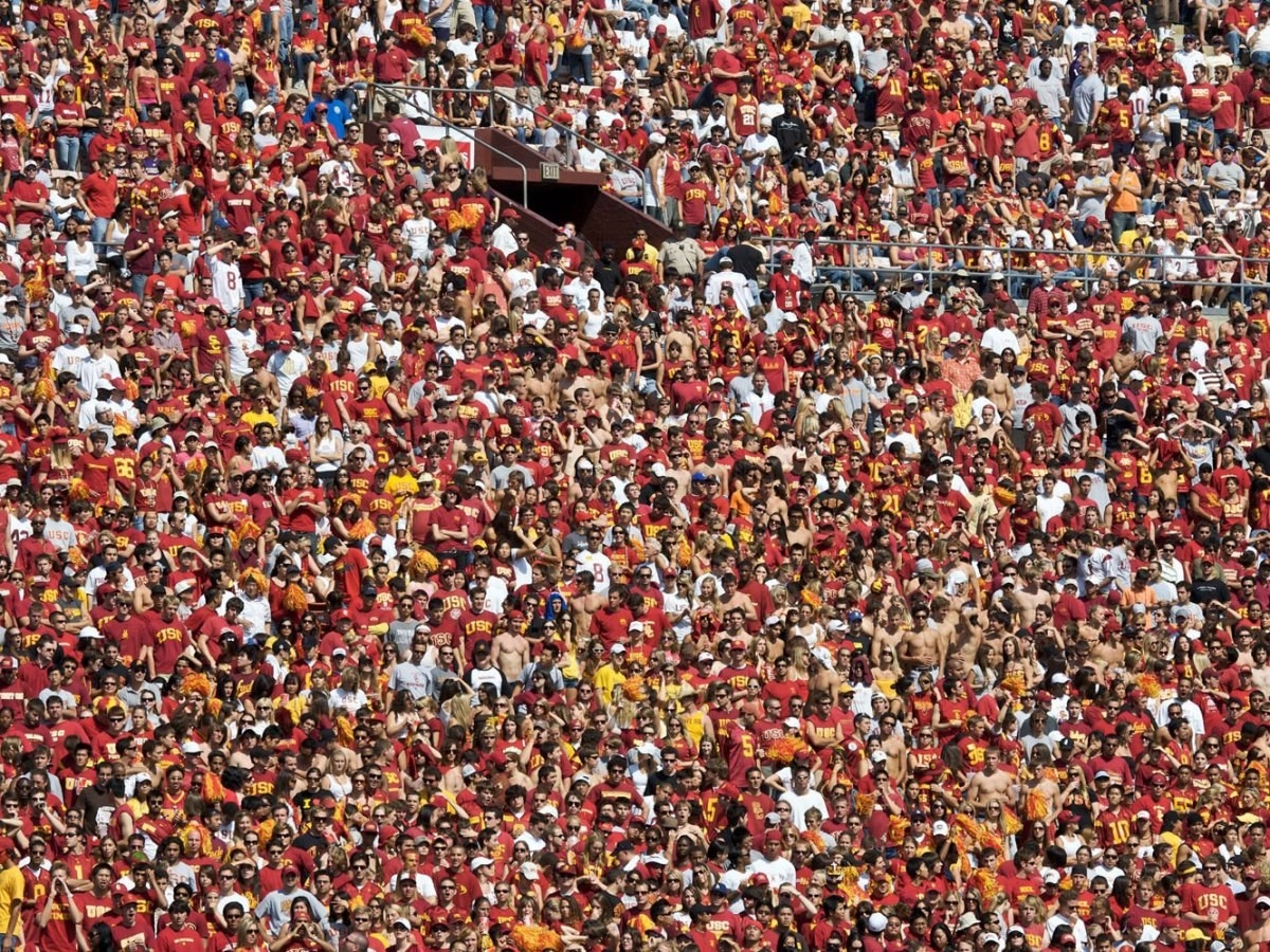 School Spirit is best shown by students coming to support their school's sports team competing with others. Students will be so proud of their school team and some of them will become life-long fans of the team even after they graduate. This picture shows students at University of Southern California coming to watch their football team, the Trojans.