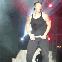 A GIF of Nick Carter wiggling on stage during a Backstreet Boys concert.