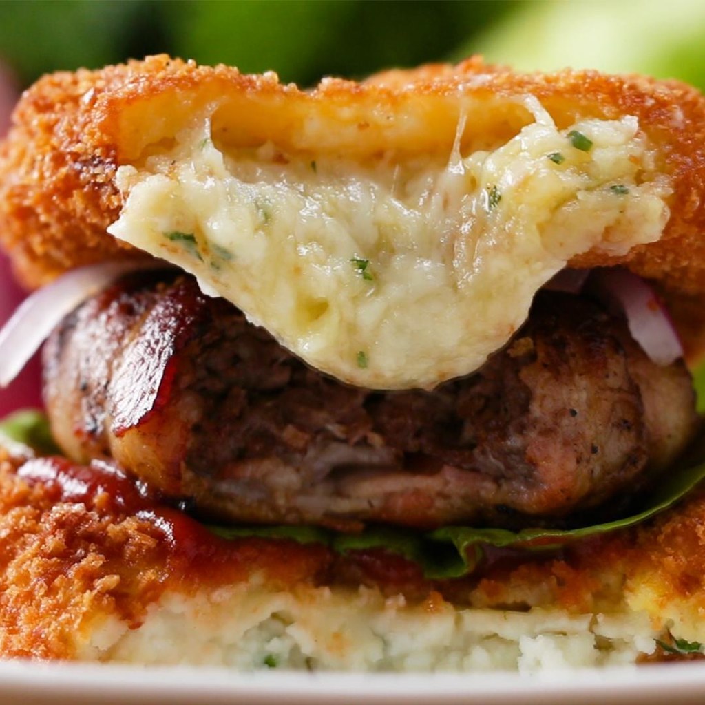 4 PortionenZUTATENKartoffelpüree-Buns5 mehlig kochende Kartoffeln, geschält und gewürfelt4 Knoblauchzehen, geschält1450ml kaltes Wasser115g Butter, gewürfelt120ml Milch Salz nach Belieben Pfeffer nach Belieben2 Esslöffel frische Petersilie, gehackt6 runde Scheiben Provolone-Käse100 g Panko5 Eier Öl, zum BratenBurger mit Speck450 g Rinderhackfleisch1 Teelöffel Salz1 Teelöffel Zwiebelpulver1/2 Teelöffel Pfeffer12 Streifel Bacon Ketchup, zum Servieren Salat, zum Servieren rote Paprikaschote, geschnitten, zum ServierenZUBEREITUNG1. Lege die Kartoffeln und den Knoblauch in einen Topf bei großer Hitze und bedecke sie mit kaltem Wasser.2. Bringe die Kartoffeln zum Kochen, reduziere die Hitze und lass sie etwa 20 Minuten köcheln, bis sie gar sind.3. Gieße die Kartoffeln durch ein Sieb ab und gib sie zurück in den Topf.4. Füge Butter, Milch, Salz und Pfeffer hinzu. Stampfe alles.5. Füge die Petersilie hinzu und vermische sie. Gib die Kartoffeln in einen Spritzbeutel oder einen wiederverschließbaren Gefrierbeutel.6. Lege die Provolone-Scheiben auf ein mit Backpapier ausgelegtes Backblech.7. Gib das Kartoffelpüree kreisförmig von außen nach innen auf die Käse-Scheiben.8. Friere das Ganze etwa eine Stunde ein, bis es fest ist.9. Gib das Ei und das Paniermehl in zwei Schüsseln.10. Gib die gefrorenen Kartoffel-Scheiben in das Ei, sodass sie vollständig bedeckt sind.11. Gib die Kartoffel-Scheiben in das Paniermehl und wende sie, um sie vollständig zu bedecken. Falls nötig, wiederhole den Vorgang, indem du die Kartoffeln wieder in das Ei gibst und dann nochmals in das Paniermehl.12. Erhitze das Öl in einem großen Topf auf 180°C.13. Gib die Kartoffeln in das Öl und brate sie, bis beide Seiten goldbraun sind, etwa 2 Minuten pro Seite.14. Lege die Kartoffelpüree-Scheiben zum Abtropfen auf ein Drahtgestell.15. Gib das Rinderhackfleisch in eine Schüssel und würze es mit Salz, Zwiebelpulver und Pfeffer. Vermische alles.16. Forme mit der Hand Patties von etwa der Größe deiner Handfläche.17. Lege den Frühstücksspeck überlappend aus, sodass zwei Streifen waagerecht und zwei Streifen senkrecht liegen.18. Gib das Burger-Patty auf den Speck und falte die Speckstreifen darüber, kürze sie falls nötig.19. Erwärme eine Pfanne bei mittlerer Hitze und füge die Speck-Patties hinzu und brate sie, bis sie durchgebraten sind.20. Stelle den Burger zusammen, indem du eine Kartoffel-Scheibe am Boden platzierst. Verteile Ketchup oder deine Lieblingssauce darüber.21. Baue den Burger weiter auf mit dem Salat, dem Patty, roten Zwiebeln und einer Kartoffel-Scheibe ganz oben.22. Guten Appetit!