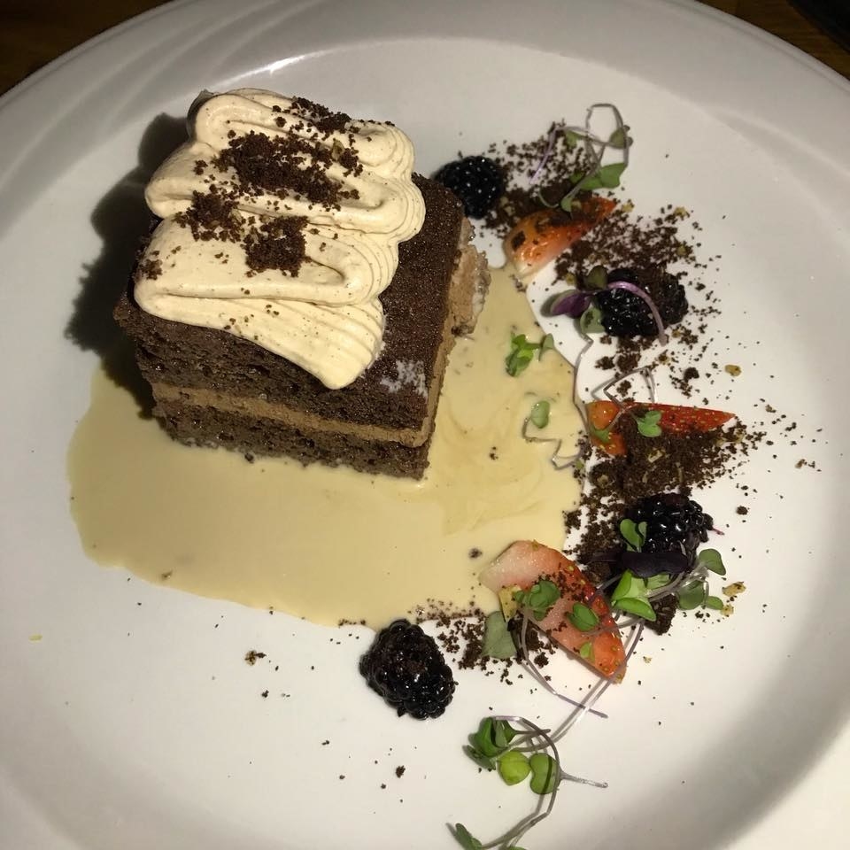Creamy tres leches sauce is poured on the table to transform the chocolate oreo cake even more moist. The delectable dessert is further beautified with garnishes like fresh berries and oreo & tortilla crumbs.