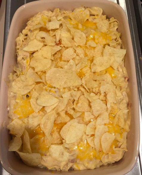 Hot canned tuna in the form of tuna noodle casserole topped with crushed potato chips.
