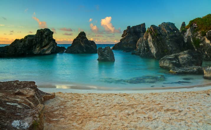 The tiny island of Bermuda floats in the Sargasso Sea, right off the coast of the Carolinas. The island is known for its colonial towns lined with pastel-colored houses, hidden coves covered in pink sand, and pleasant year-round weather perfect for golfing, swimming, or sun-bathing. Bermuda is also influenced by a mixture of British, West Indian, and Portuguese cultures, which is evident in the island's eclectic cuisine.