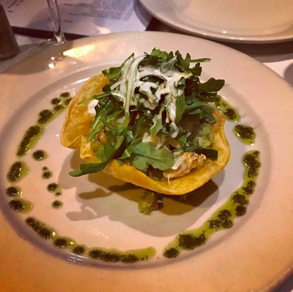Served in a crunchy taco shell, the Avocado Crab Salad features fresh lump crabmeat with guacamole made of ripe avocado, tomato, and onion. The crab salad is topped with bed of arugula with yogurt dressing.