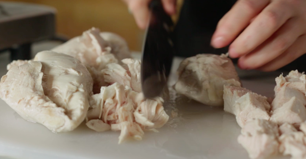 After the chicken was fully cooked, Alix had to cut it into small pieces, and lay it out in a deep baking dish.