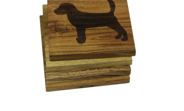 A set of handmade wooden coasters with engraved dog designs.