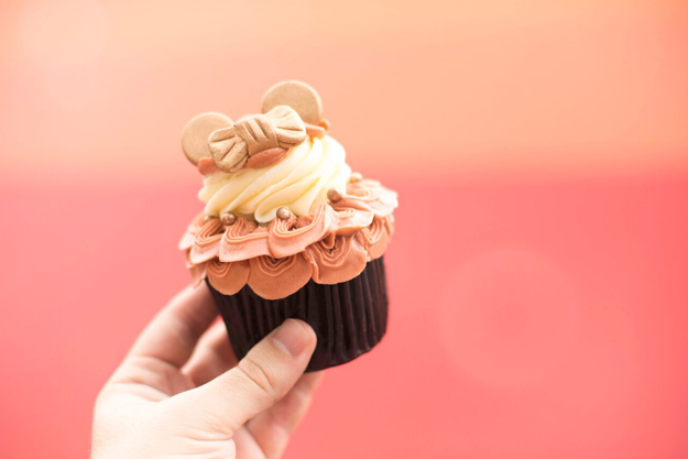 This super pretty vanilla cupcake with hazelnut swirl, rose gold buttercream, fondant ears, edible glitter, and chocolate pearls.
