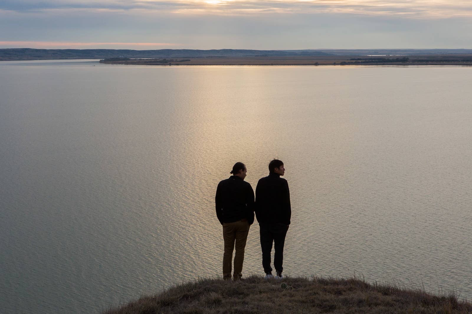 Joseph White Eyes and Danny Grassrope stand on a bluff overlooking the Missouri River on the Lower Brule Reservation in South Dakota on Nov. 8, 2017. Grassrope grew up in Lower Brule and returned there with White Eyes after the #NoDAPL camps in Standing Rock were evicted in early 2017. Grassrope and White Eyes are now working as environmental activists in Lower Brule and beyond.