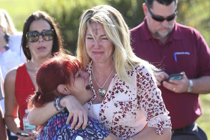 Parents wait for news after a reports of a shooting at Marjory Stoneman Douglas High School in Parkland, Florida.