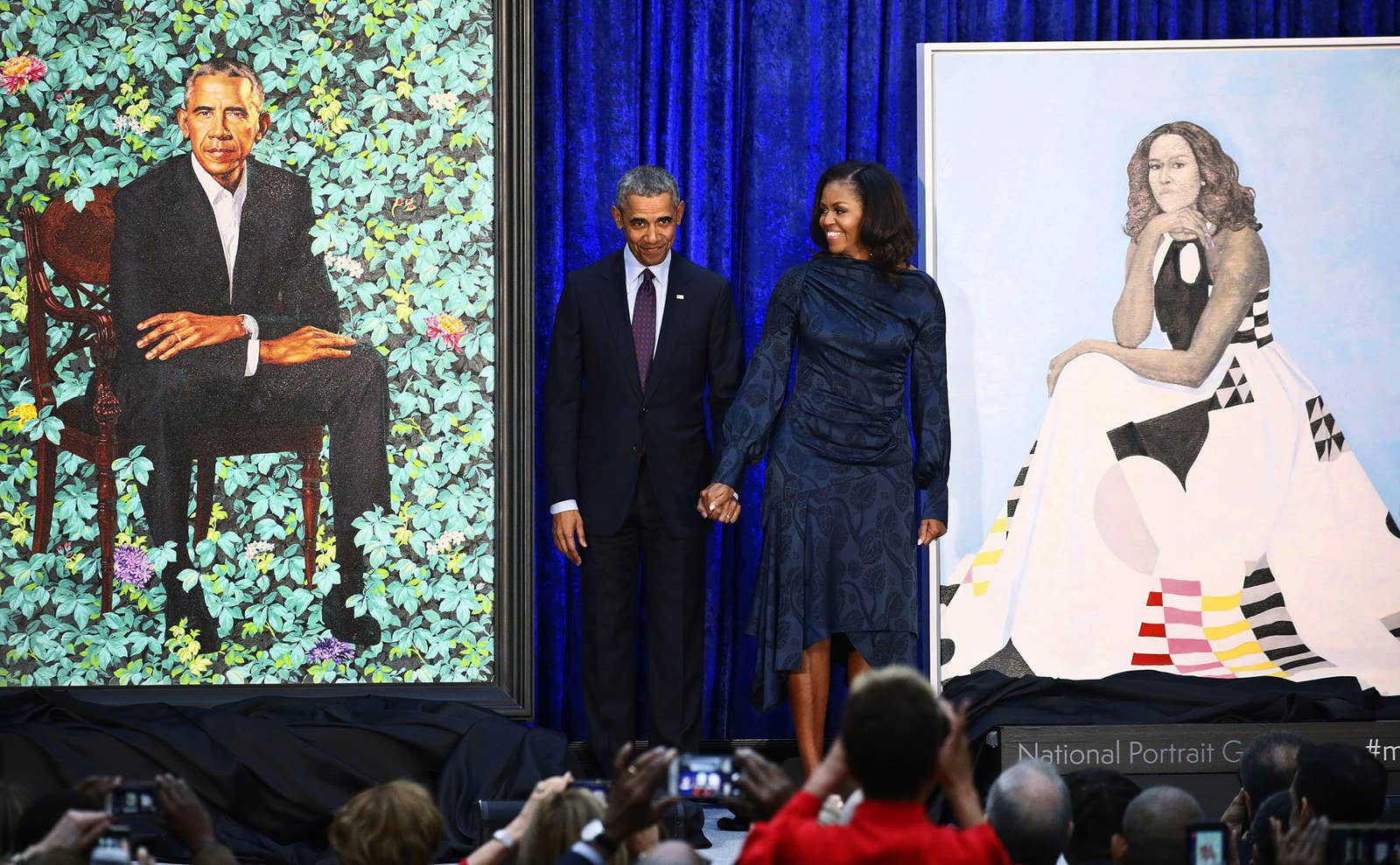 Former US president Barack Obama and former first lady Michelle Obama hold hands between their portraits during an unveiling ceremony at the Smithsonian's National Portrait Gallery in Washington, DC, on Feb. 12.