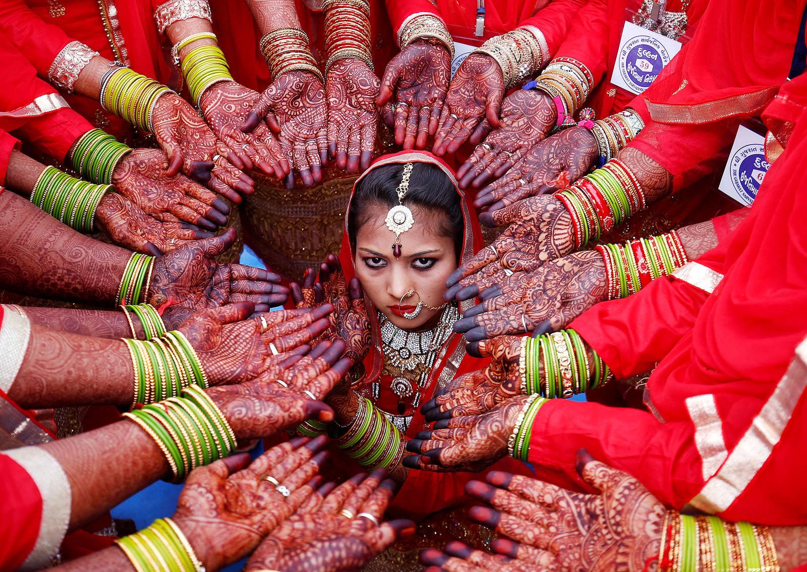 Brides display their hands decorated with henna during a mass marriage ceremony in which, according to its organizers, 70 Muslim couples took their wedding vows in Ahmedabad, India, on Feb. 11.