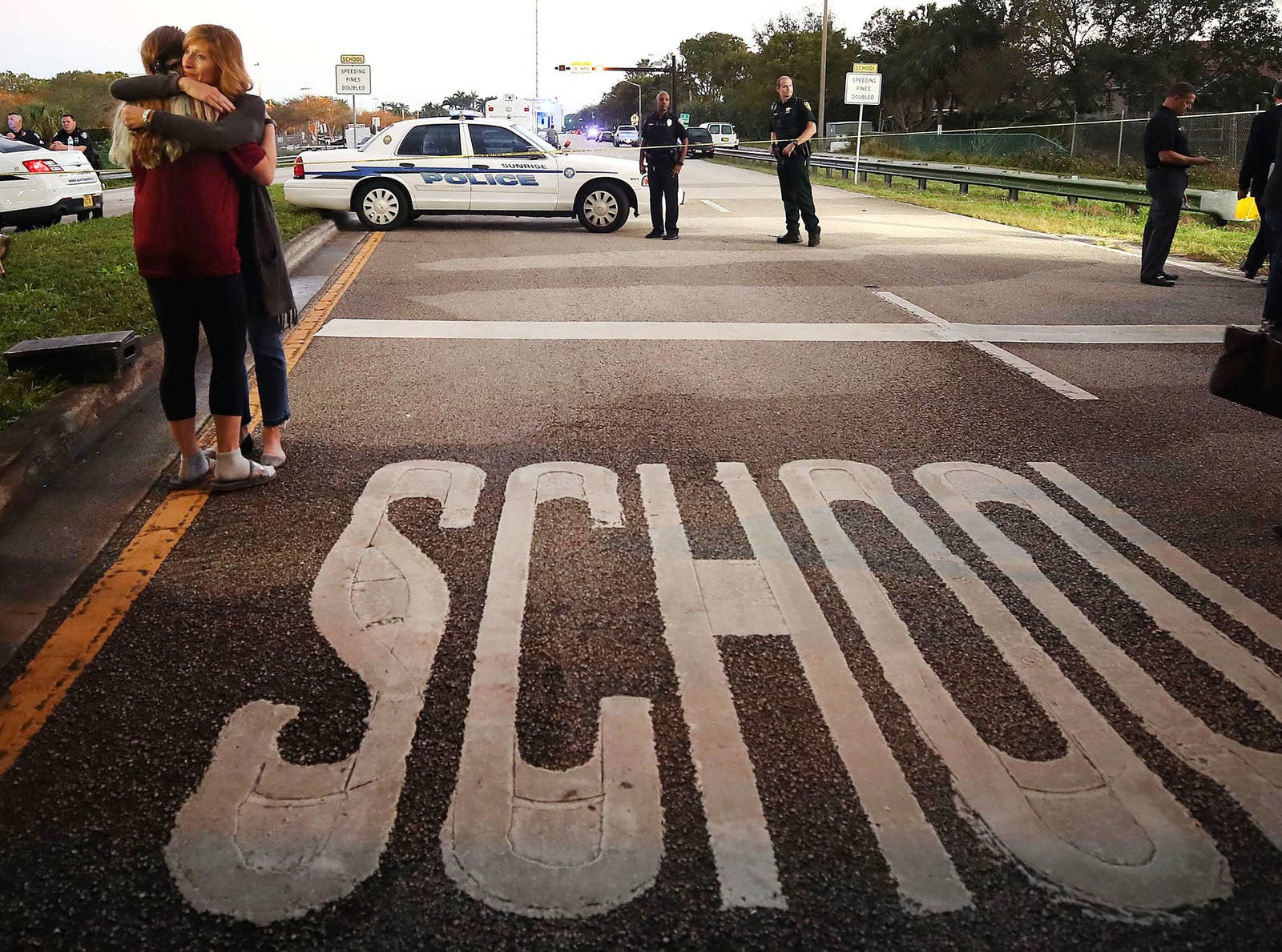 Kristi Gilroy (right) hugs a young woman at a police checkpoint near the Marjory Stoneman Douglas High School on Feb. 15, the day after 17 people were killed by a shooter at the Parkland, Florida, school. Police arrested the suspect after a short manhunt.