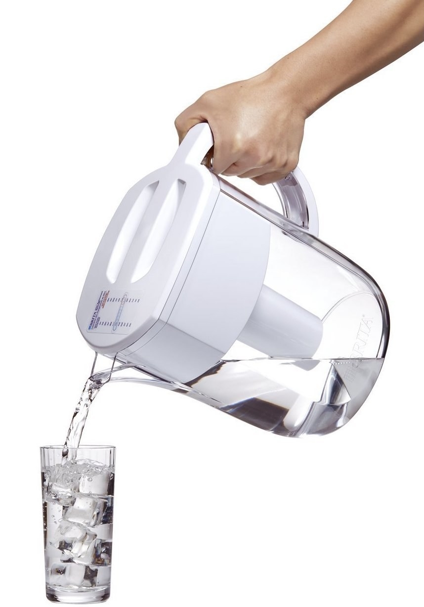 person pouring water from a brita into a glass