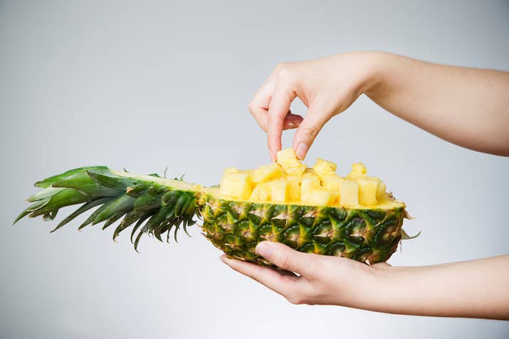Fresh pineapples contain bromelain, an enzyme which breaks down proteins and essentially attacks your tongue, cheeks, and lips on contact. It's basically "tenderising" the inside of your mouth. But don't worry, your cells regenerate quickly.