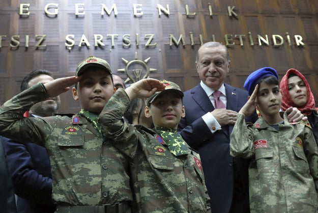 And here he is with children in commando uniforms outside the floor of Turkey's parliament last Tuesady.