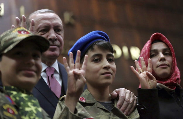 And here they are holding up four fingers, symbolizing Erdogan's current mantra of "one nation, one state, one homeland, one flag."