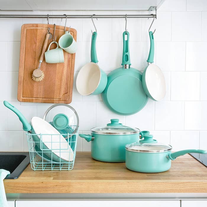 Image shows teal cooking wear on a wooden counter.