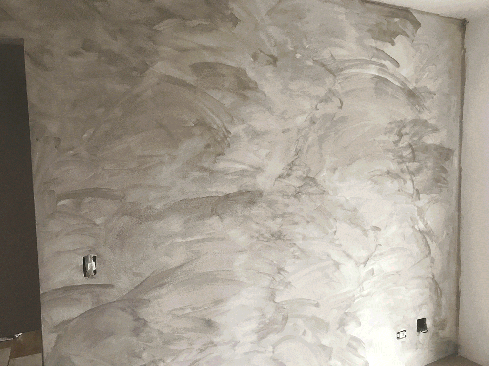 No último mês eu mudei de apartamento e resolvi dar um tchan na sala, que era toda branca. Sempre fui fã desse estilo de parede hipster chamado cimento queimado, mas nunca tinha visto em um apartamento que custasse menos de um milhão de reais, então sempre achei que era algo fora do meu orçamento.Uma amiga minha levantou a bola de que existiam tintas que conseguiam imitar esse efeito de um jeito bem legal e fui procurar. Na internet a maioria dos bloggeiros de decoração e sites especializados no assunto falavam dessa mesma tinta, a Cromanil. Pelos vídeos que eu vi, parecia que qualquer um seria capaz, por isso resolvi testar.Vou confessar que foi mais difícil achar um lugar pra comprar essa tinta do que aplicá-la em casa. Tudo o que você precisa é do galão de tinta, uma esponja para aplicar (que veio junto) e verniz para finalização. Eu passei umas três mãos de tinta pra ficar no tom que eu queria, mas se você quiser mais claro pode parar antes. Uma dica de ouro é: nas últimas camadas procure repetir os movimentos conforme você for aplicando. Fica mais uniforme e homogêneo como um todo. Eu consegui fazer tudo sozinho em uma tarde e olha que eu nem sou tão esperto assim! – Nicolas Vendramini