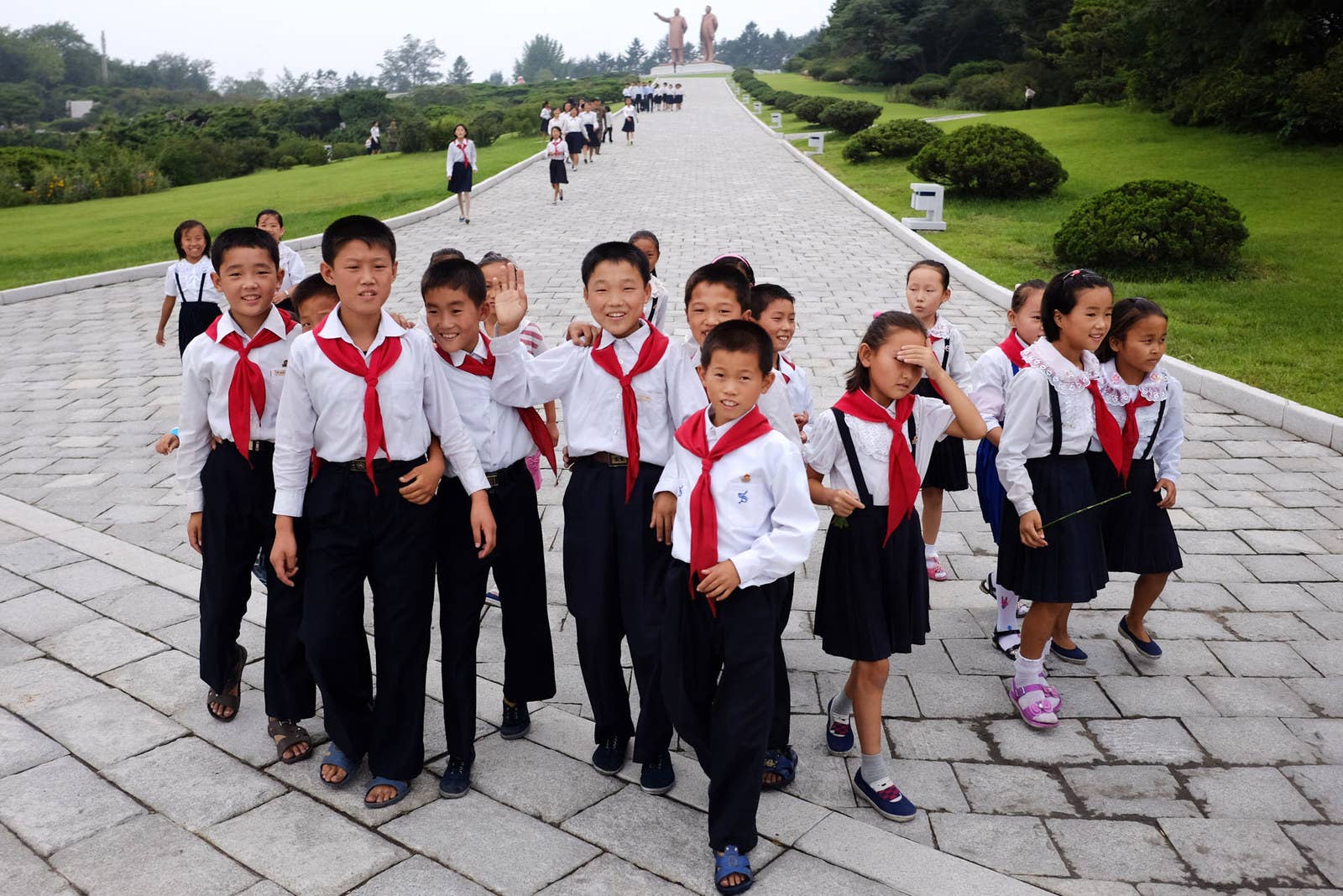 Schoolchildren make their way from the leaders' statues in central Hamhung.