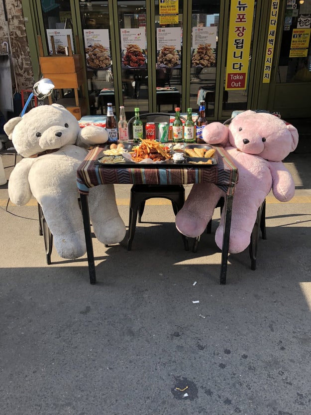A restaurant featuring two giant stuffed bears eating food.