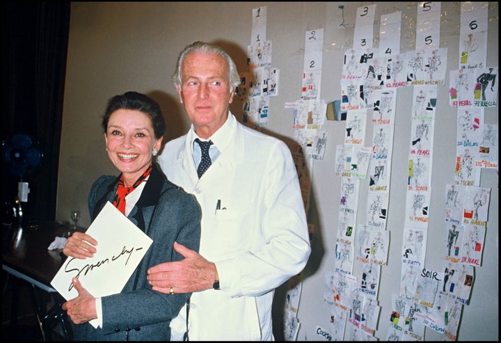 Hubert De Givenchy greets the press with Audrey Hepburn after presenting his 1986 Summer collection.