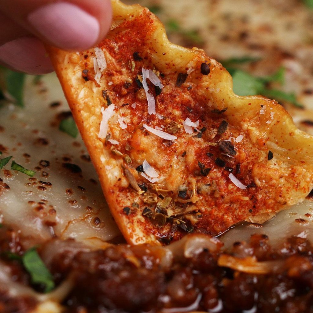 30 servingsINGREDIENTS455 g (16 oz) lasagna noodle60 mL (1/4 cup) water3 tablespoons olive oil, divided145 g (1 1/3 cups) grated parmesan cheese, divided, plus more for serving3 1/2 teaspoons salt, divided2 teaspoons dried basil2 teaspoons dried oregano2 teaspoons paprika1 teaspoon garlic powder1 tablespoon unsalted butter1/2 medium yellow onion, minced25 g (1/4 cup) carrot, minced55 g (1/4 cup) celery, minced2 cloves garlic, minced225 g (1/2 lb) ground beef225 g (1/2 lb) italian sausage75 g (1/3 cup) tomato paste3/4 teaspoon black pepper, divided60 mL (1/4 cup) red wine250 g (1 cup) ricotta cheese20 g (1/2 cup) spinach, chopped1 tablespoon fresh basil, chopped1/2 cup shredded mozzarella cheese italian parsley, chopped, for servingPREPARATION1. Cook the noodles according to package directions, omitting salt. Drain well and separate the noodles carefully.2. Cut the noodles into triangles and transfer to baking sheet.3. In a small bowl, combine the water and 2 tablespoons of olive oil. Brush on both sides of noodles.4. Combine 2 teaspoons of salt, the dried oregano, dried basil, paprika, and garlic powder in a small bowl, and mix to combine.5. Sprinkle the seasoning mixture and â
cup (35 g) of Parmesan cheese over the noodles. Set aside.6. Heat the remaining tablespoon of olive oil and the butter in a large skillet over medium-high heat.7. Add the minced onion, carrot, and celery. Cook, stirring occasionally, until golden brown, 5-10 minutes.8. Once the vegetables have caramelized, add the ground beef, Italian sausage, ½ teaspoon of salt, ¼ teaspoon of pepper, and the tomato paste. Stir to combine, breaking up the meat.9. Cook until the meat has browned, 15-20 minutes.10. Add the red wine. Bring the sauce to a simmer, cover with a lid, and cook for 30 minutes, stirring occasionally, then set aside.11. Preheat the oven to 400°F (200°C).12. In a large bowl, mix together the ricotta, spinach, fresh basil, remaining cup of Parmesan cheese, remaining teaspoon of salt, and remaining ½ teaspoon of pepper.13. Spread half of the meat sauce in the bottom of an ovenproof dish.14. Gently spread the ricotta cheese over the sauce.15. Spoon the remaining meat sauce over the ricotta and sprinkle mozzarella cheese on top.16. Bake the noodles and layered dip for 12 minutes, or until the cheese is melted and the noodle chips are crispy.17. Sprinkle more Parmesan cheese on top of noodle chips, if desired.18. Sprinkle parsley on top of dip, if desired.19. Enjoy!Inspired by:http://www.geniuskitchen.com/recipe/lasagna-chips-214127