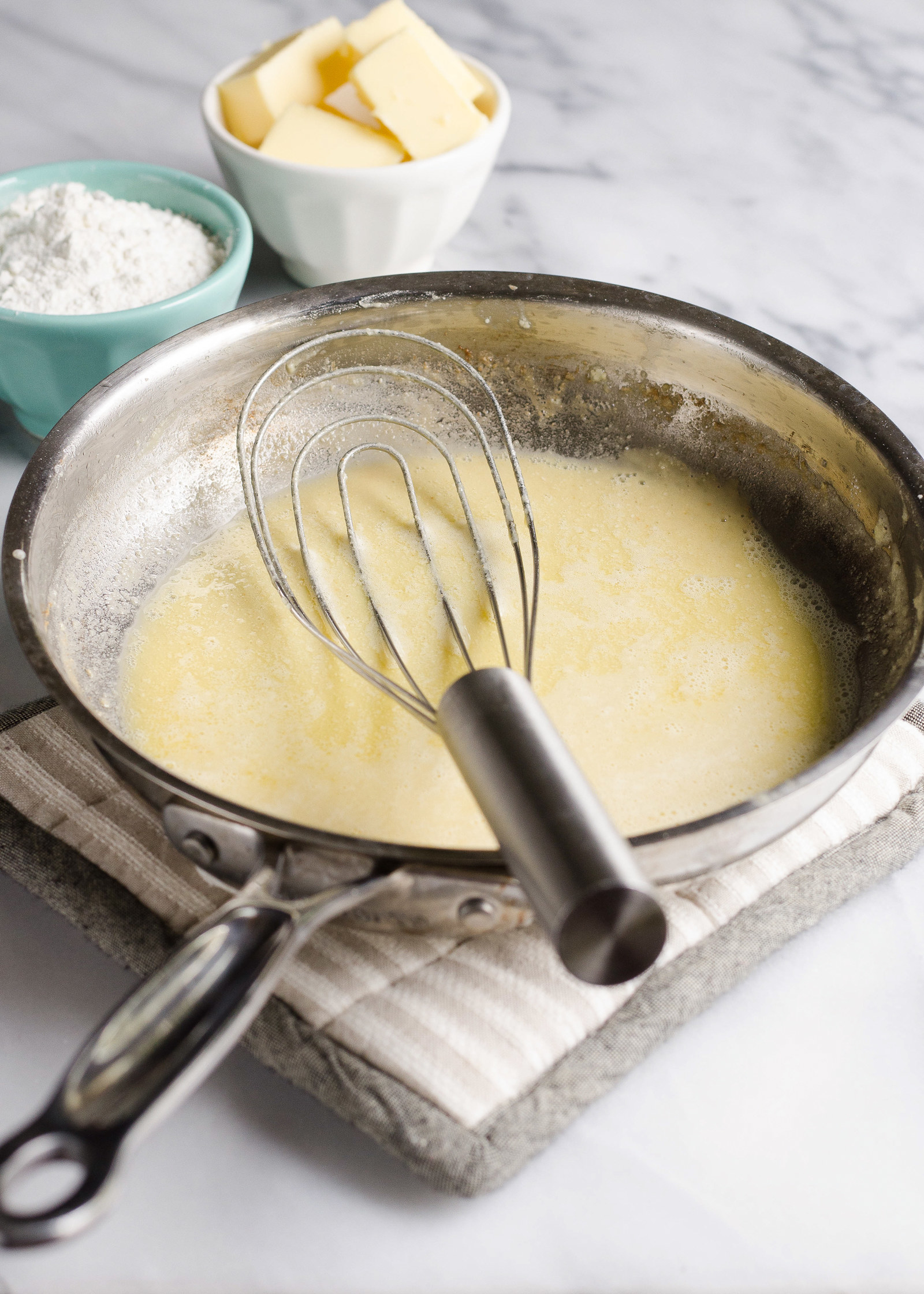 A whisk in a pan with roux inside