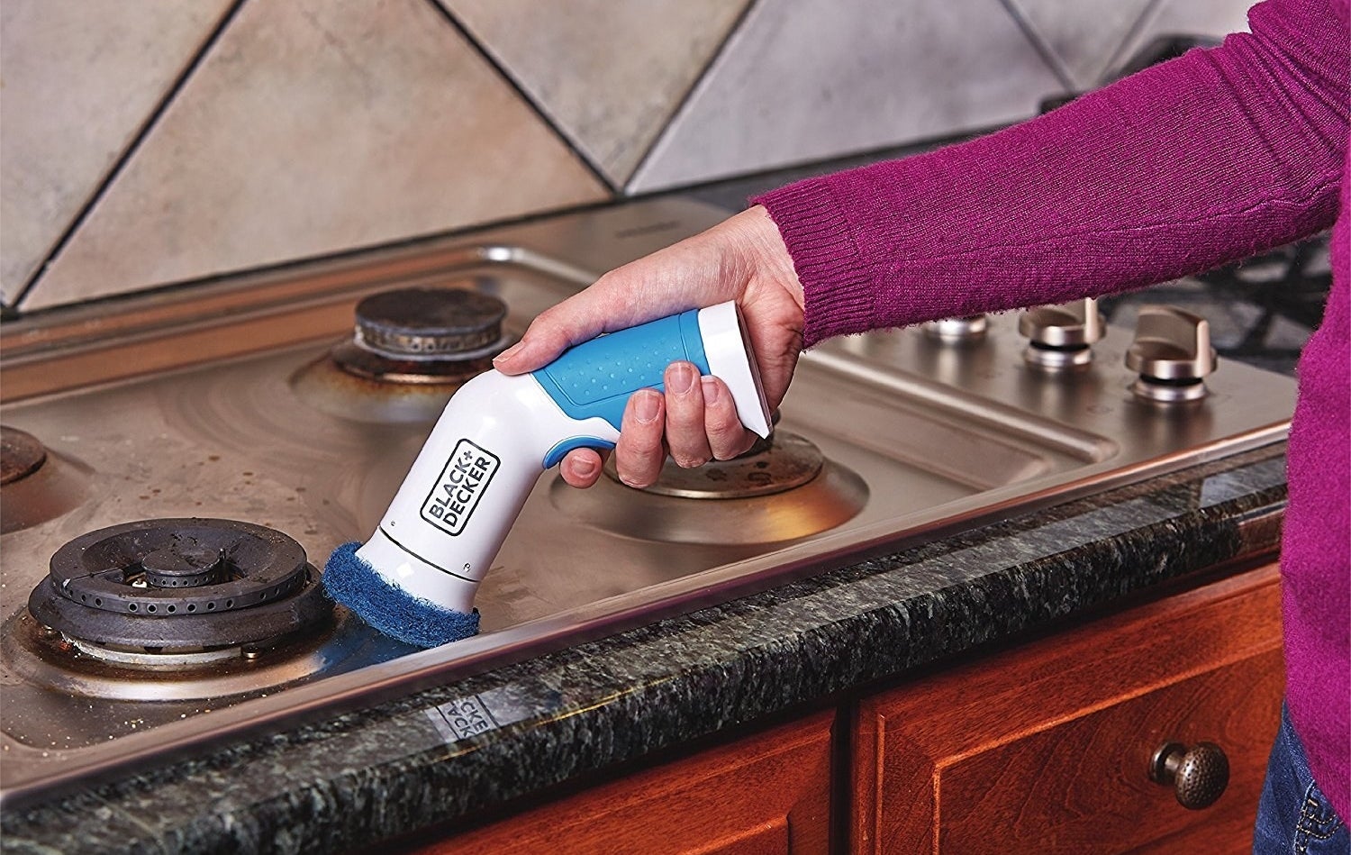 model uses scrubber on stove