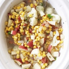 Ingredients like corn and potatoes in a slow cooker