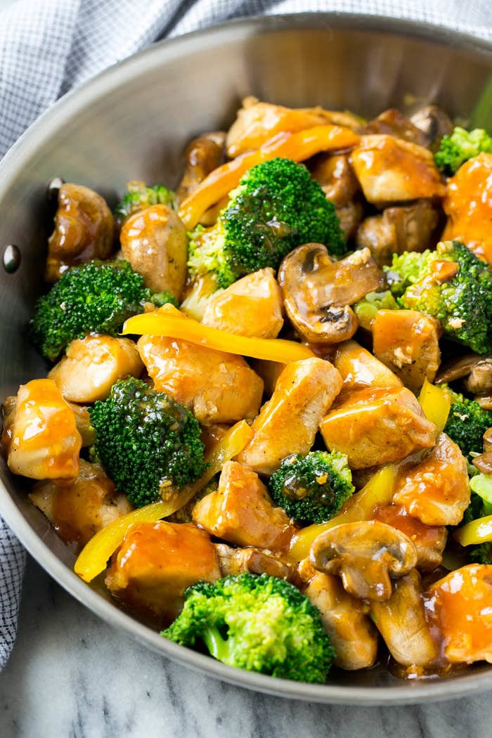 A pan of the stir fry with chicken, mushrooms, and broccoli