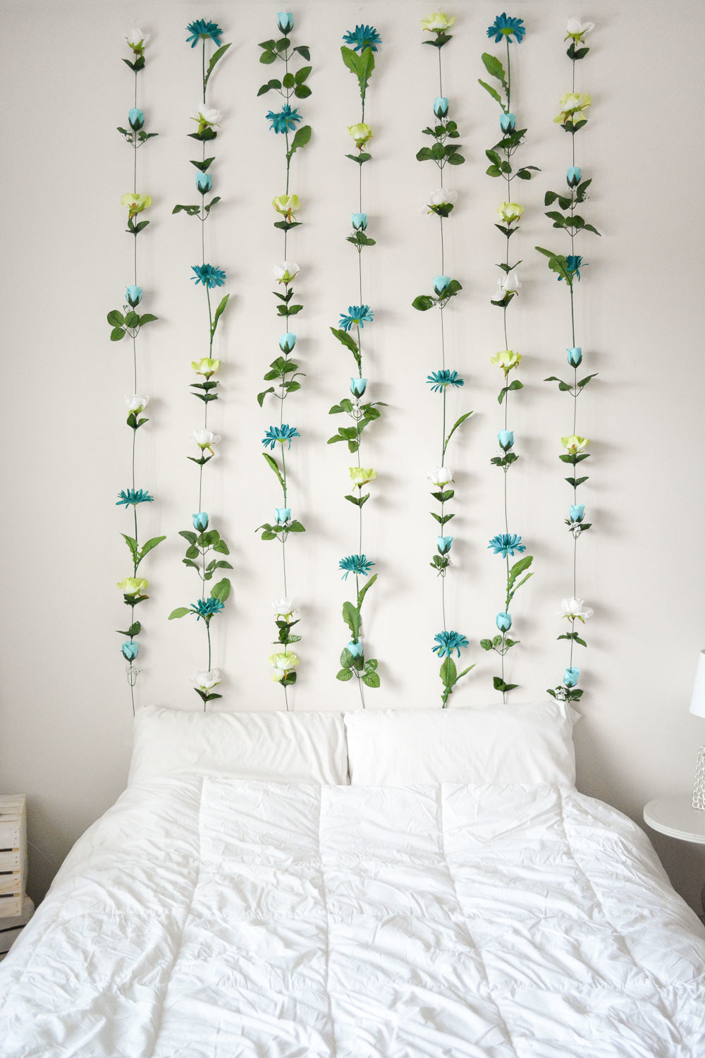 strings of fake flowers above a bed