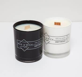 a black candle next to a white minimalist design next to a white candle with black design, both with thick wood wicks