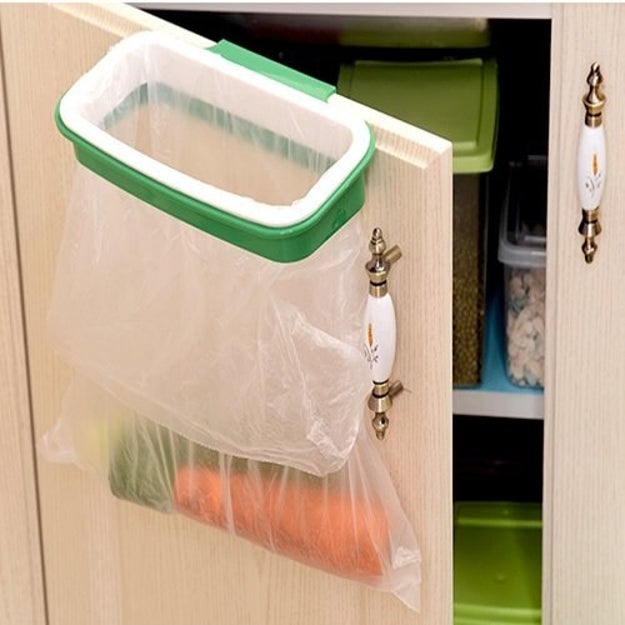 Clean up your messes as you go along to avoid the dreaded aftermath of cooking by sweeping everything into a cupboard garbage bag holder. No more, "well I don't want to deal with scraps" — they're already gone, calm down.