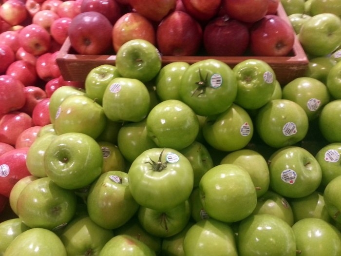 Bins of red and green apples displayed for sale