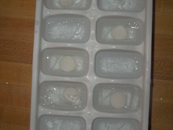 Ice cube tray half-filled with frozen cubes