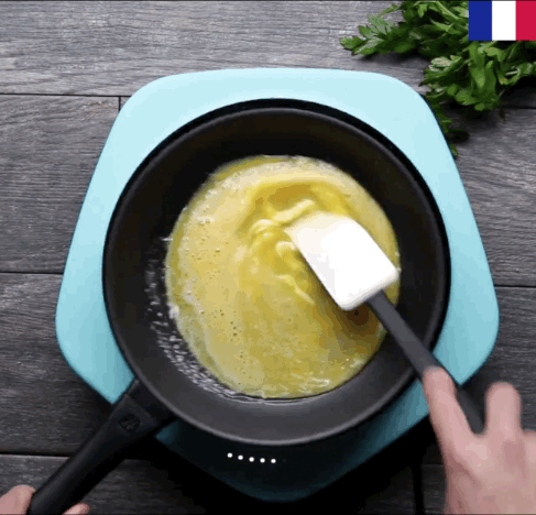 For the perfect French omelet, you need to stir the egg mixture so it doesn't develop a brown crust, all the while shaking the pan on the heat, so it doesn't turn into scrambled eggs. Once the egg starts to curdle, let the omelet sit without stirring or shaking the pan so that it finishes cooking. That's also when you can add your toppings, before folding the omelet and serving it right away.