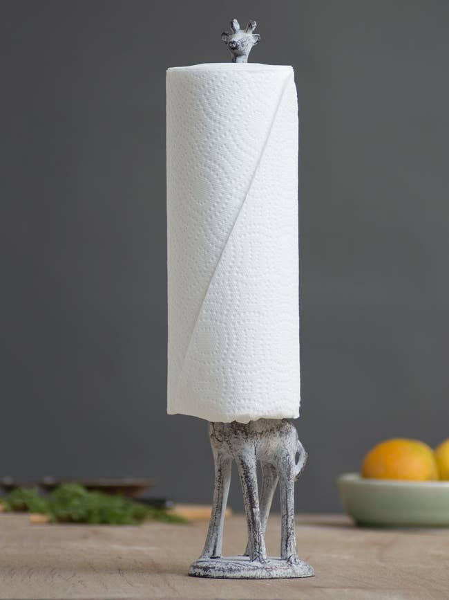 giraffe shaped paper towel holder with paper towels around its neck