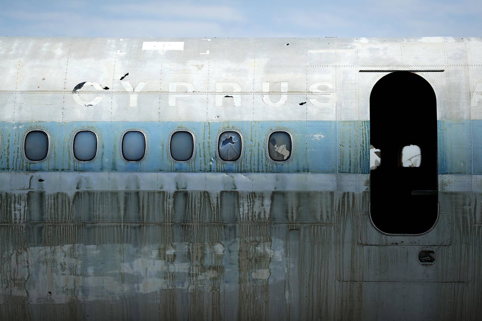 A abandoned and decaying Cyprus Airways passenger plane sits on the runway.