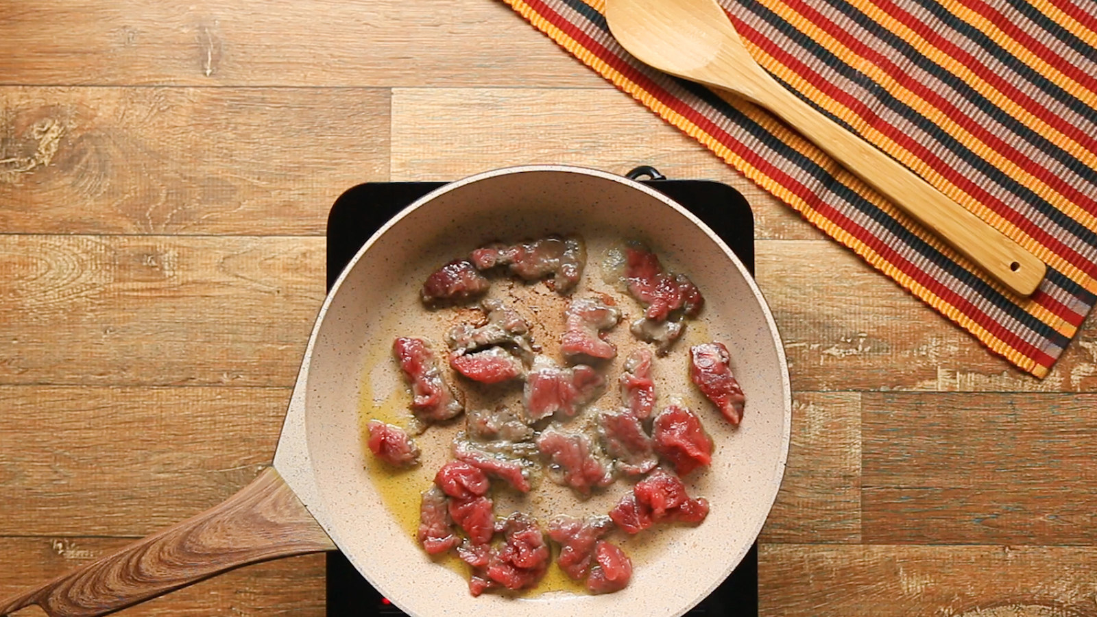 1. Tempere a carne com o açúcar, o azeite, o sal e a pimenta.2. Frite os pedaços da carne, selando os lados até dourar.3. Adicione a cebola, o extrato de tomate, o creme de leite, a cebolinha e a salsinha.4. Desligue o fogo e adicione o cogumelo.5. Cozinhe a batata na água até ficar macia. 6. Corte as batatas ao meio, sentido vertical, e preencha o fundo de uma travessa resistente ao forno com metade delas.7. Recheie com o estrogonofe e a muçarela, depois coloque a outra metade das batatas por cima, fazendo um sanduichinho.8. Pincele a manteiga e finalize com o parmesão.9. Gratine a 200ºC por 20 minutos ou até dourar.10. Aproveite!